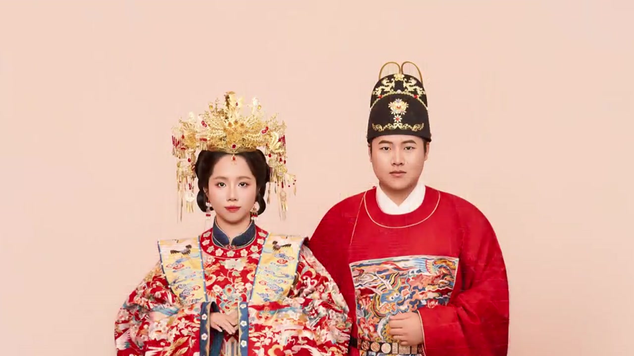 中式婚服新人站在浅色背景前